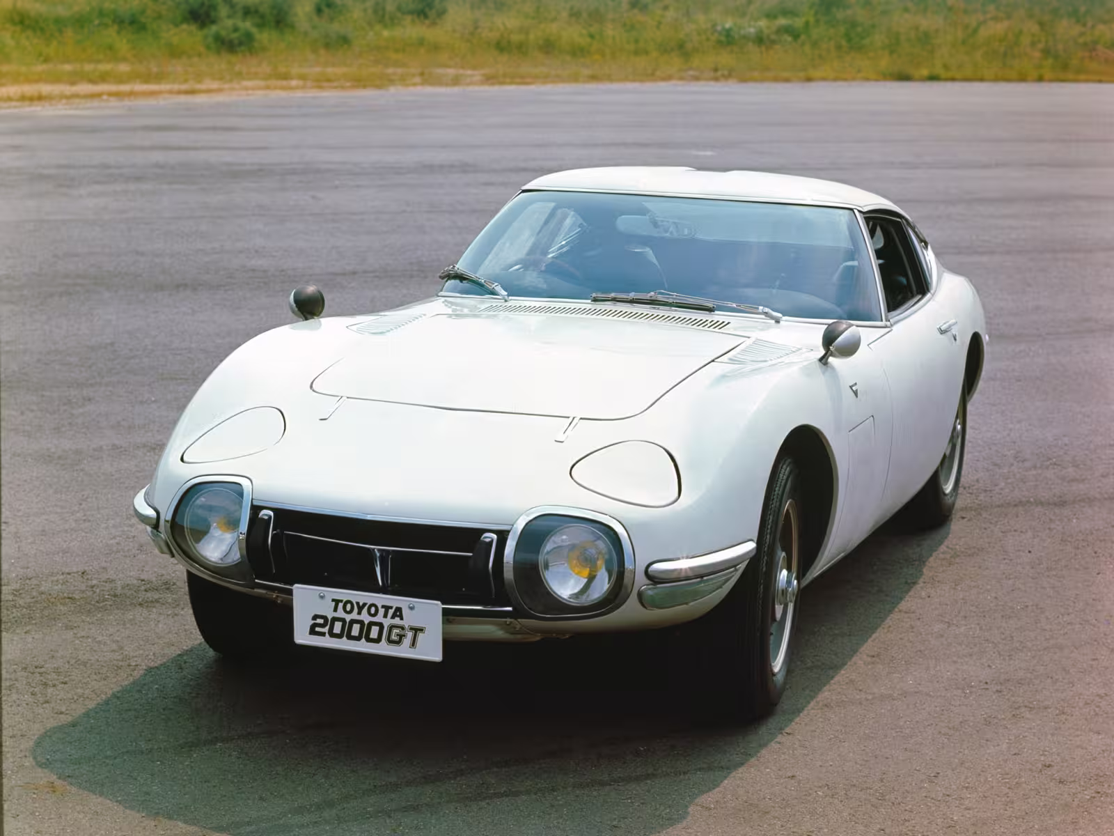 Toyota 2000GT em imagem oficial com destaque para o perfil baixo do cupê