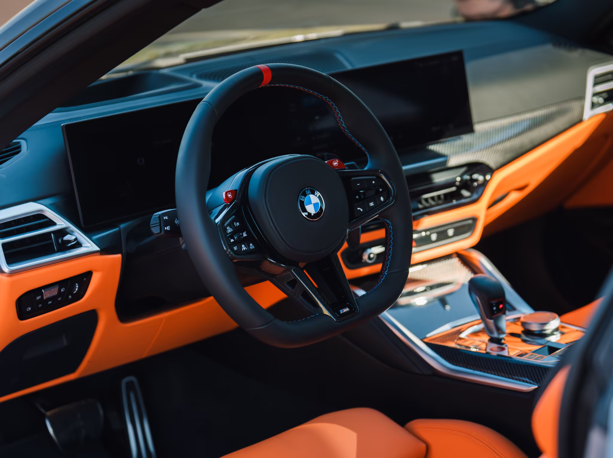 Interior do BMW M4 Competition com tela curva e acabamento esportivo