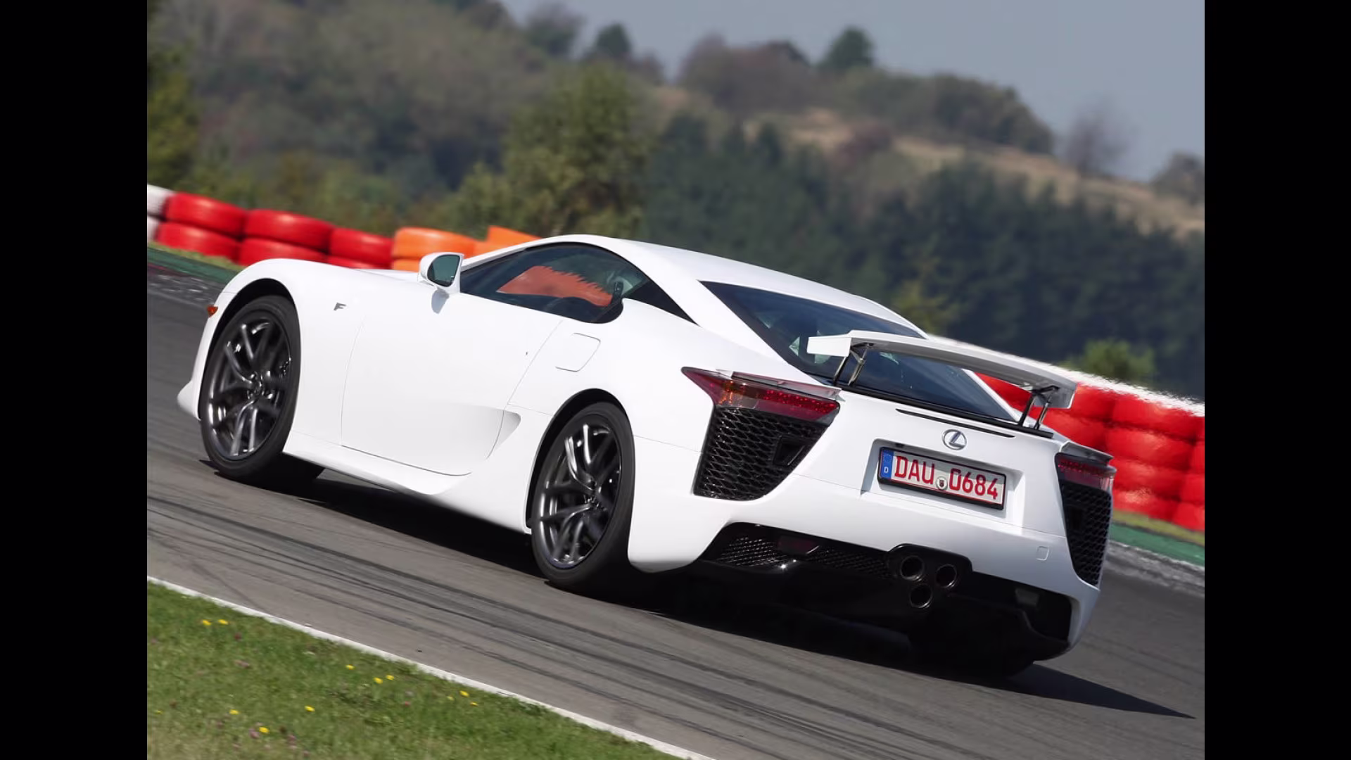 Traseira do Lexus LFA branco mostrando o clássico aerofólio ativo e as três saídas de escape centrais.