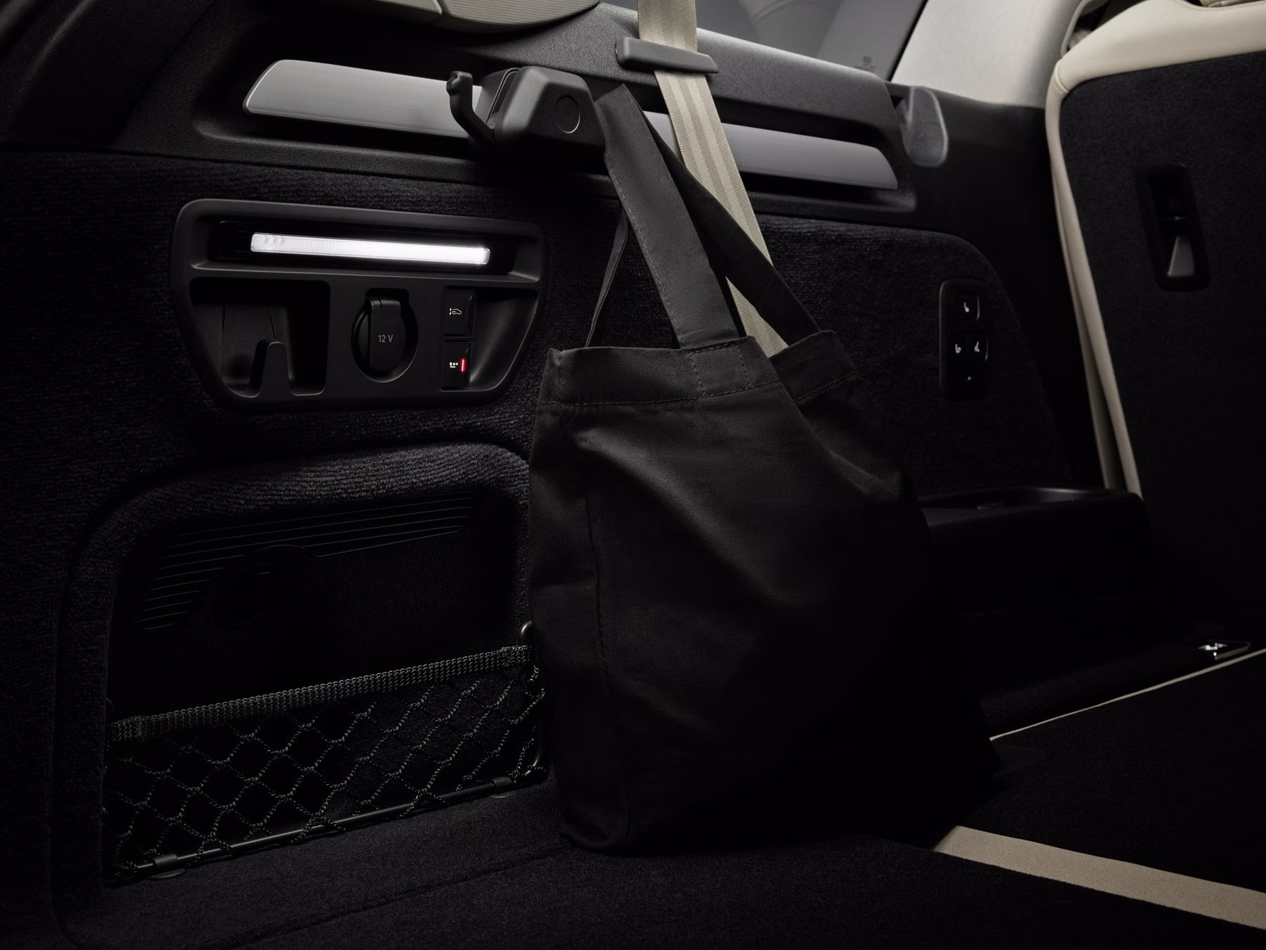 Área traseira do Audi Q7 com bolsa presa junto aos bancos e conexões laterais