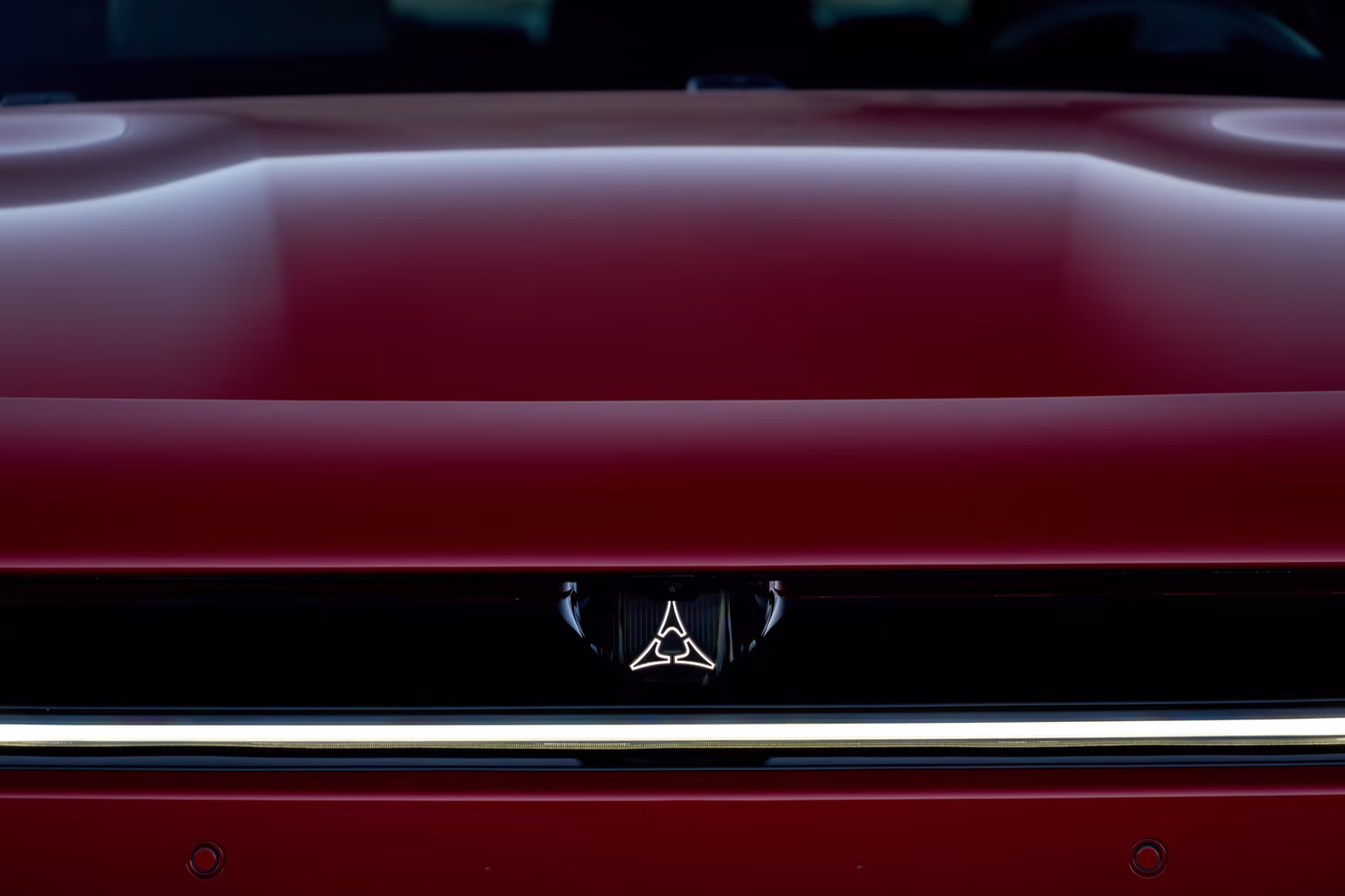 Detalhe traseiro do Dodge Charger vermelho com emblema Fratzog iluminado