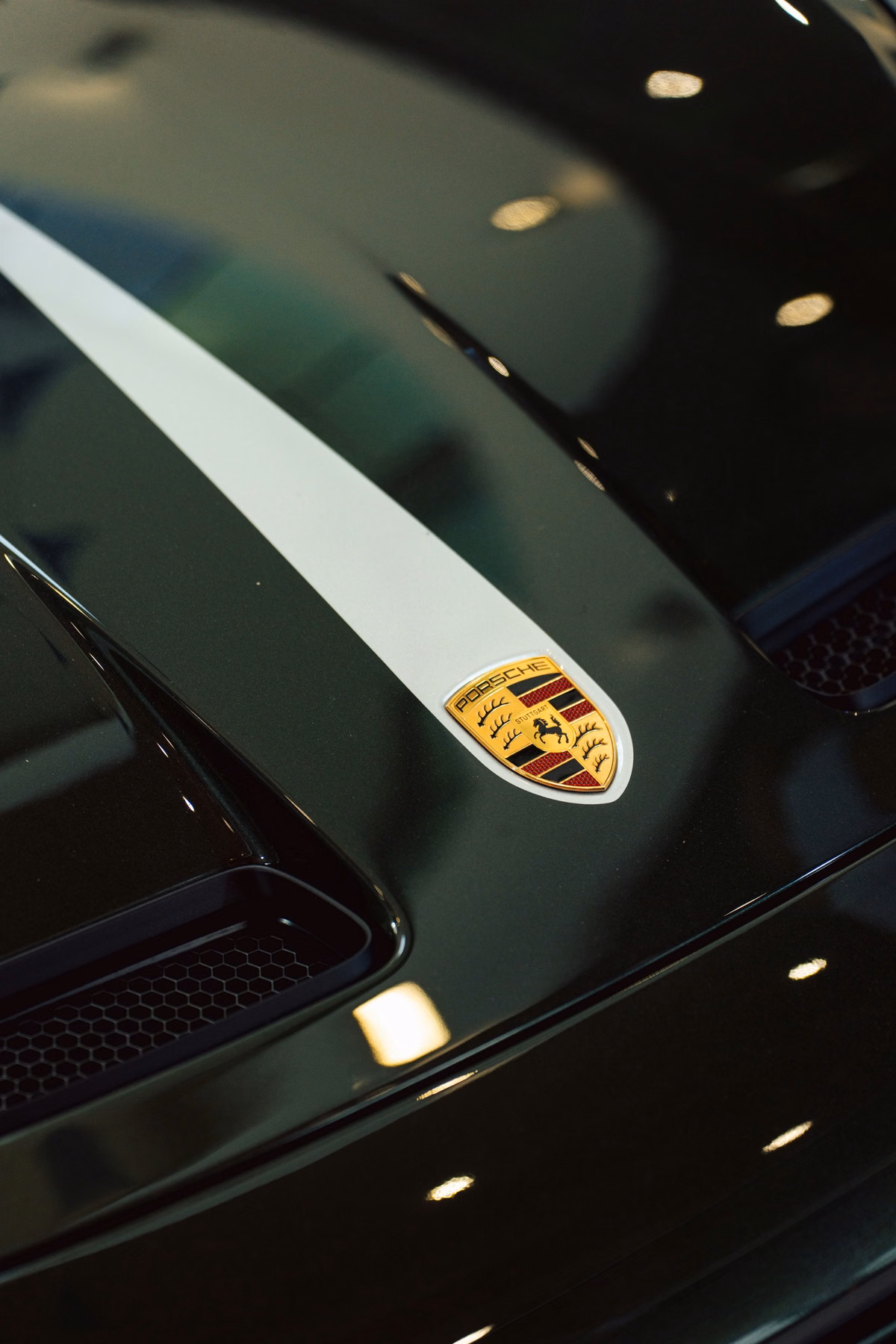 Detalhe do capô com emblema Porsche em carro verde no Sunstede Silverstone Edition